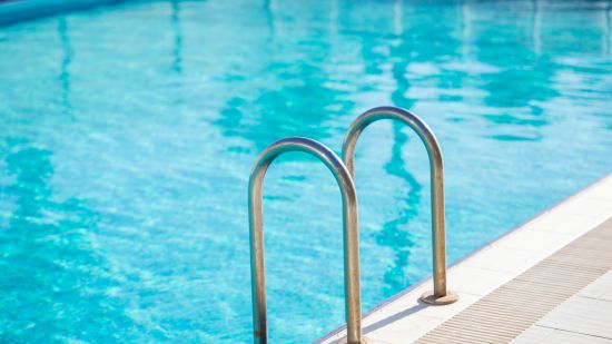 a view of a swimming pool with a ladder placed by its side