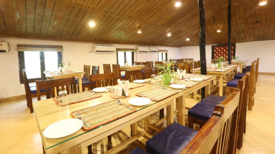 A dining setup with wooden furnished table and chair- Lotus Eco Beach Resort, Konark.