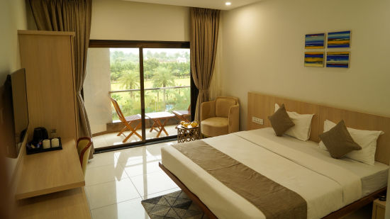Pride Ranakpur Resort Convention Centre - Interior view of the suite featuring a king size bed a television and a balcony containing a coffee table