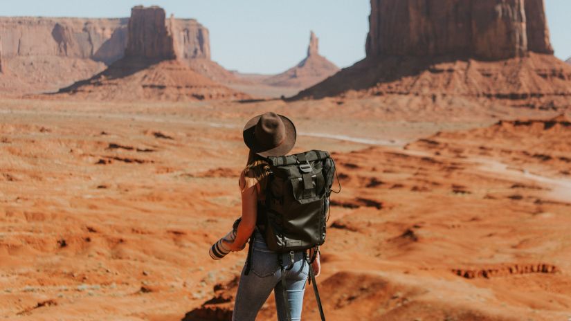 a woman with backpack on a trek in the desert