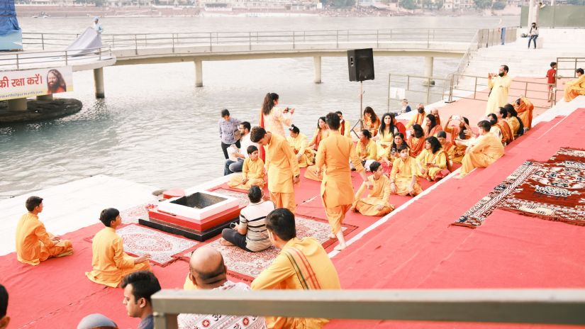 People dressed in saffron resting near the river at Parmarth Niketan Ashram