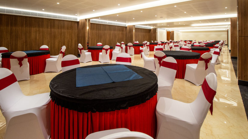 A banquet hall with round tables and white seats 2 - The Residences at CSE