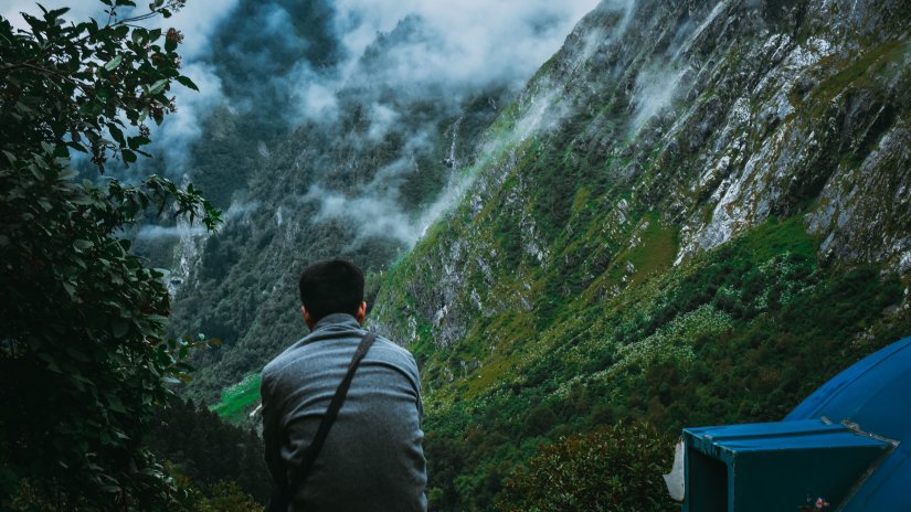 A person looking at mountains and clouds