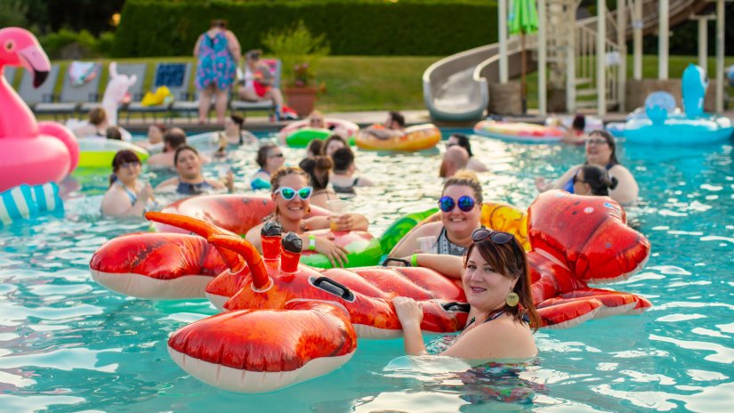 People swimming in the pool with inflated toys