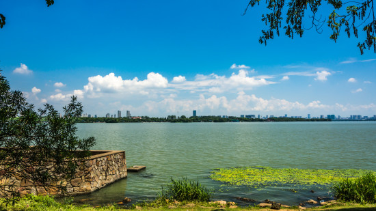 A tranquil waterway surrounded by lush vegetation, with boats gently gliding on the surface