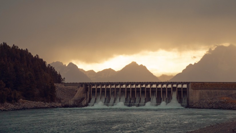 front view of a dam on a river captured during sunset with a cloudy sky