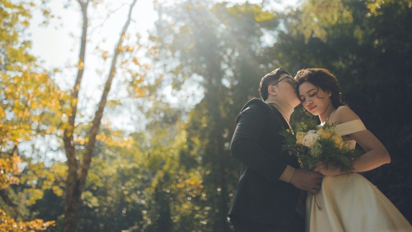 A groom kissing the bride on forehead