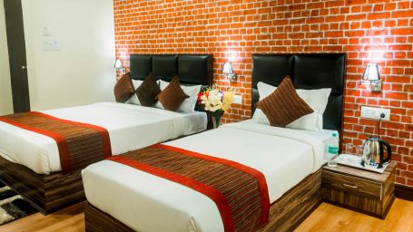 An image of the deluxe room with twin bed, bed side tables, and other modern amenities - Ecotel Tin Tin, Bijanbari