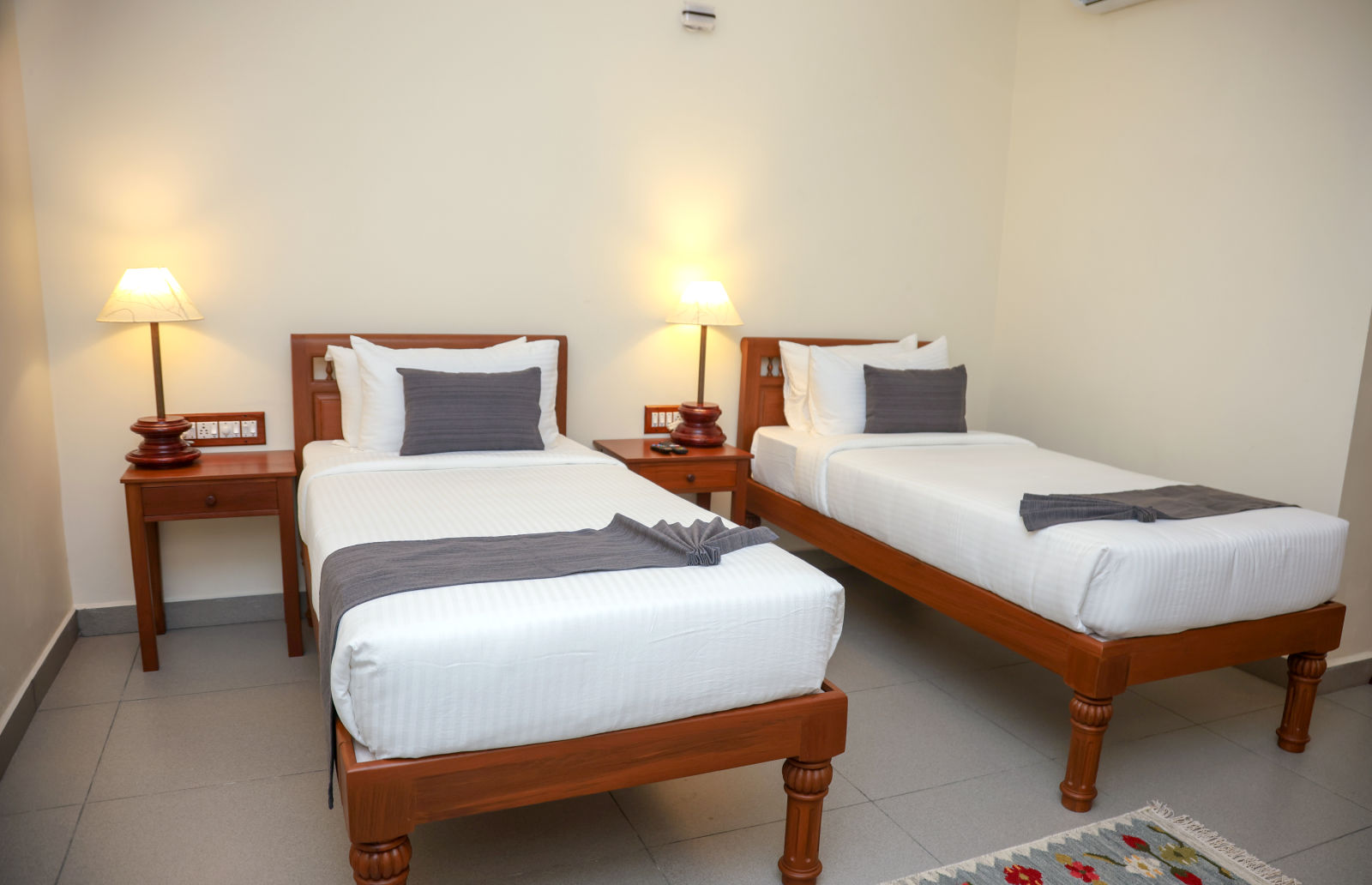 A room that has two similar looking bed with a bedside table beside them  | Mango HIll La Serene, Ponicherry