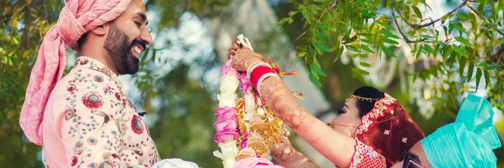 bride and groom garlanding each other 1