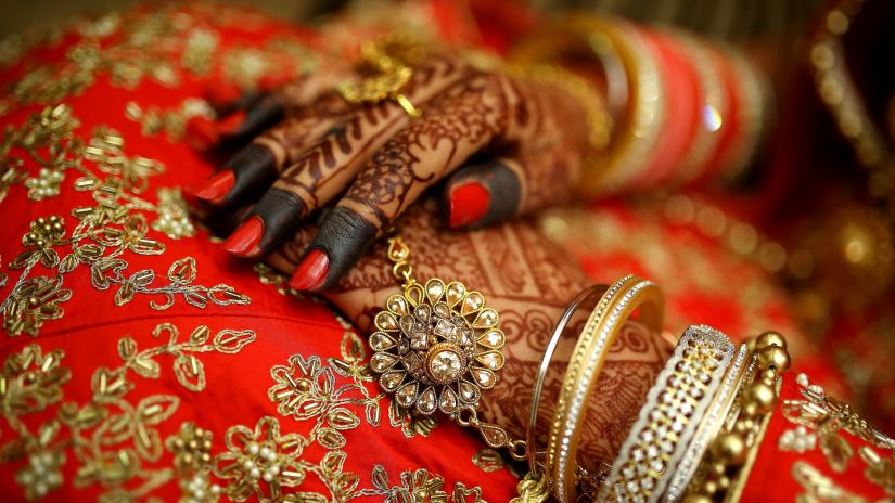 a close up shot of a Bride wearing traditional bangles and rings