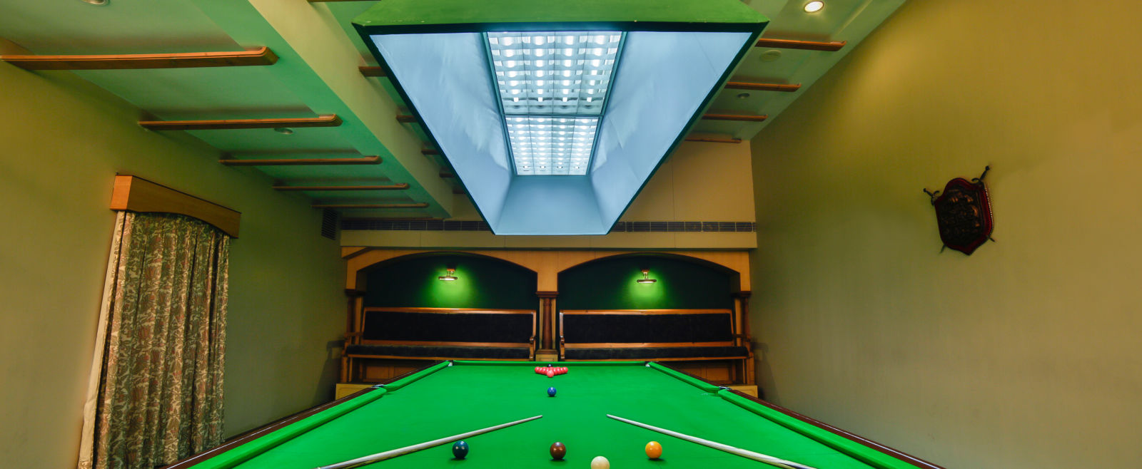 pool table with billiards cue sticks placed at the corners at Hotel Tara, Hyderabad