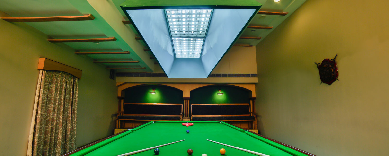 pool table with billiards cue sticks placed at the corners at Hotel Tara, Hyderabad