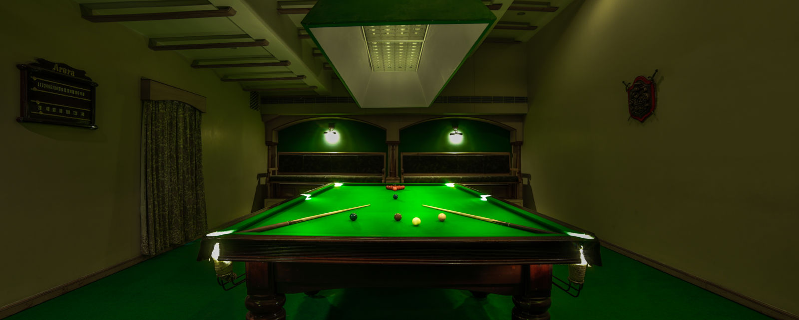 pool table with billiards cue sticks placed at the corners at Hotel Tara, Hyderabad