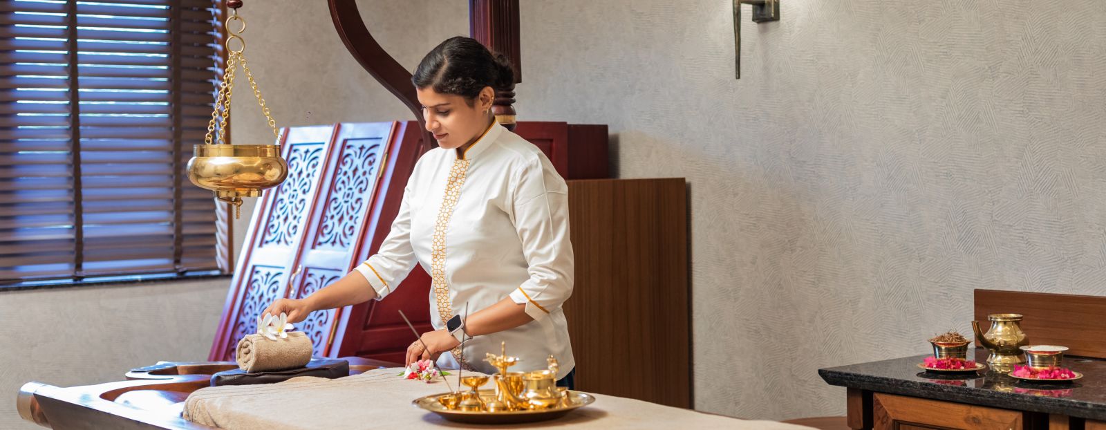 a massage therapist setting up a table for shirodhara treatment