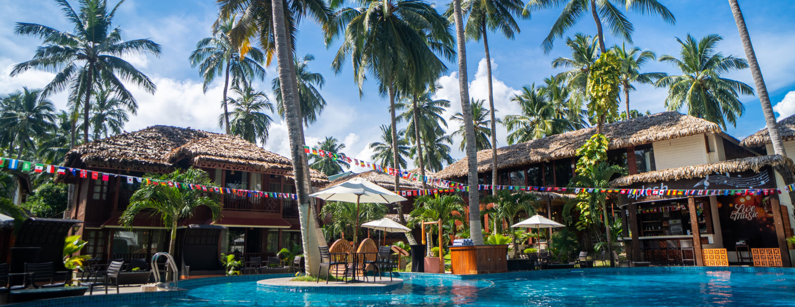 Pool with cocount trees on the side at Coral Reef Hotel & Resort