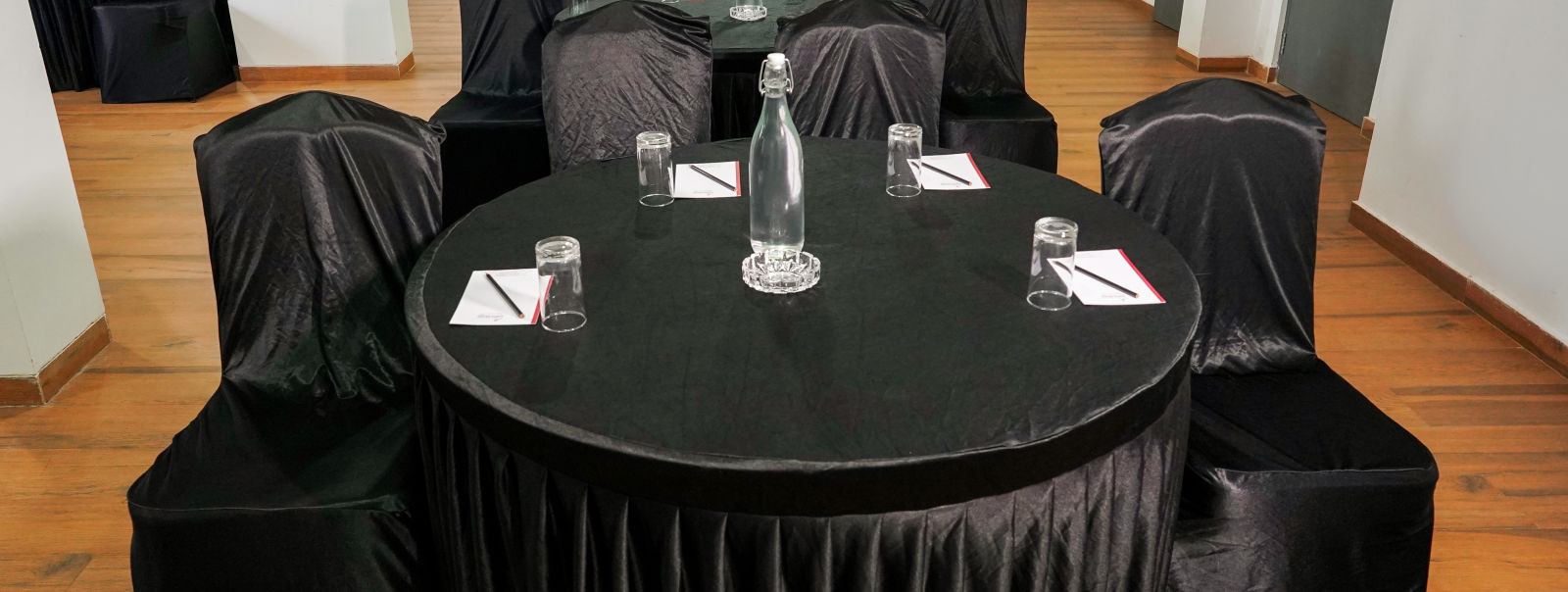 A close view of round tables and chairs covered in black in our conference room - TGI Ameya Grand, Goa