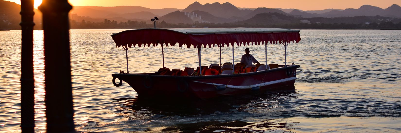 A lonely boat in the lake with sunset in the background