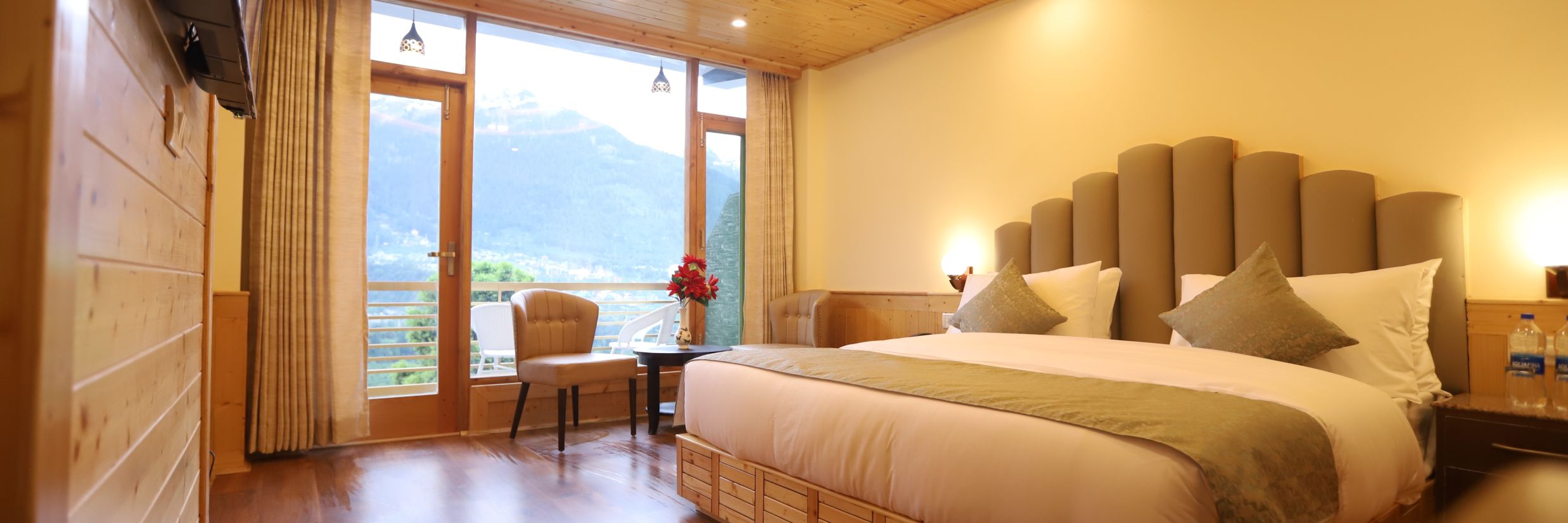 side angle view of premium room that shows the wide open balcony and the panoramic view outside - Golden Wood Manali By Rosetum