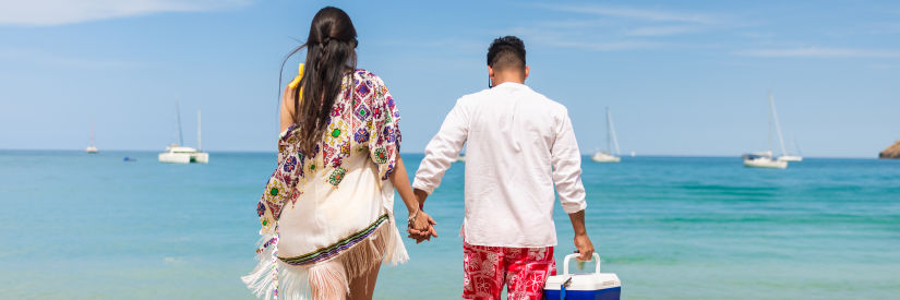 a couple walking on the beach - The Soco House