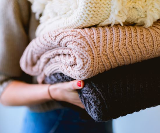 alt-text A person holding folded laundry