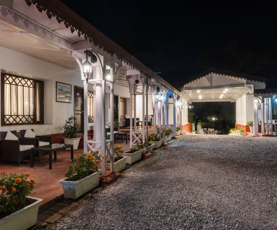 alt-text A side-angle shot capturing the facade of The Claridges Nabha Residence in Mussoorie, taken at night