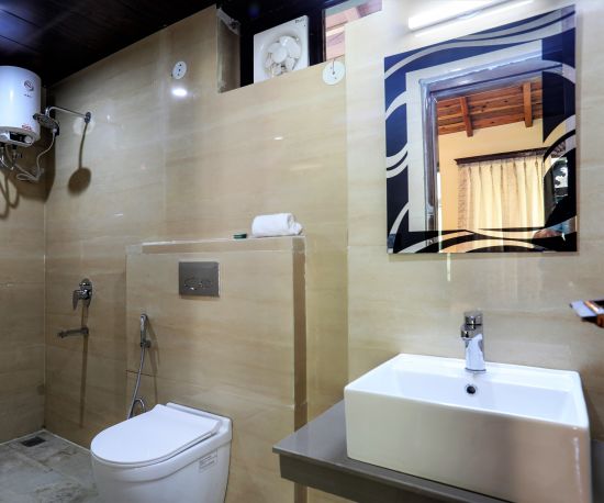 alt-text A bathroom with a sink, a square mirror, a geyser, a western toilet and a shower space - Vinsober Monal, Nainital