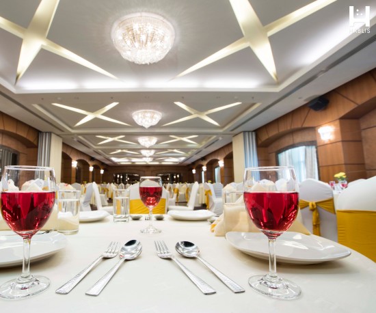 alt-text Glasses and plates arranged in Magnum banquet hall in Chennai at Hablis Hotel, Chennai