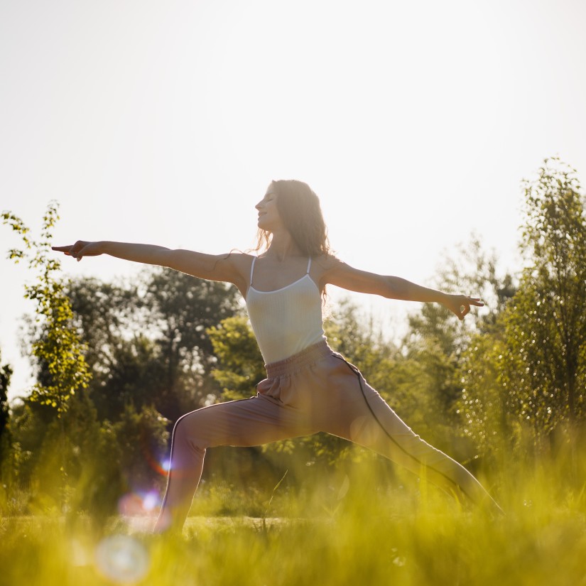 a woman doing a yoga pose during daytime while the sun shines