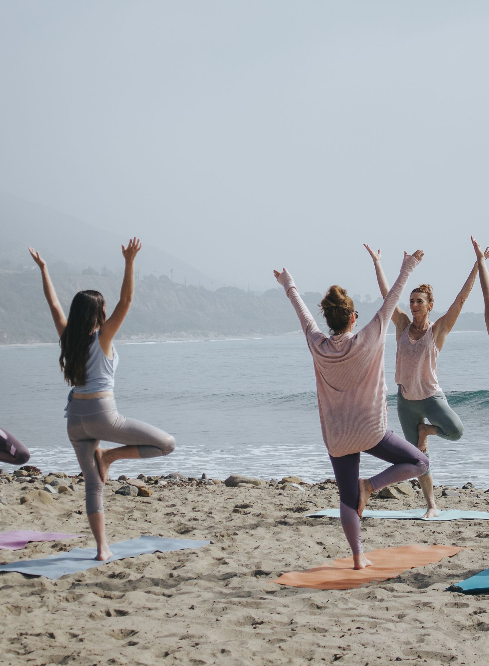 People practicing yoga on the beach - Monsoon and ayurveda - gamyam Retreat