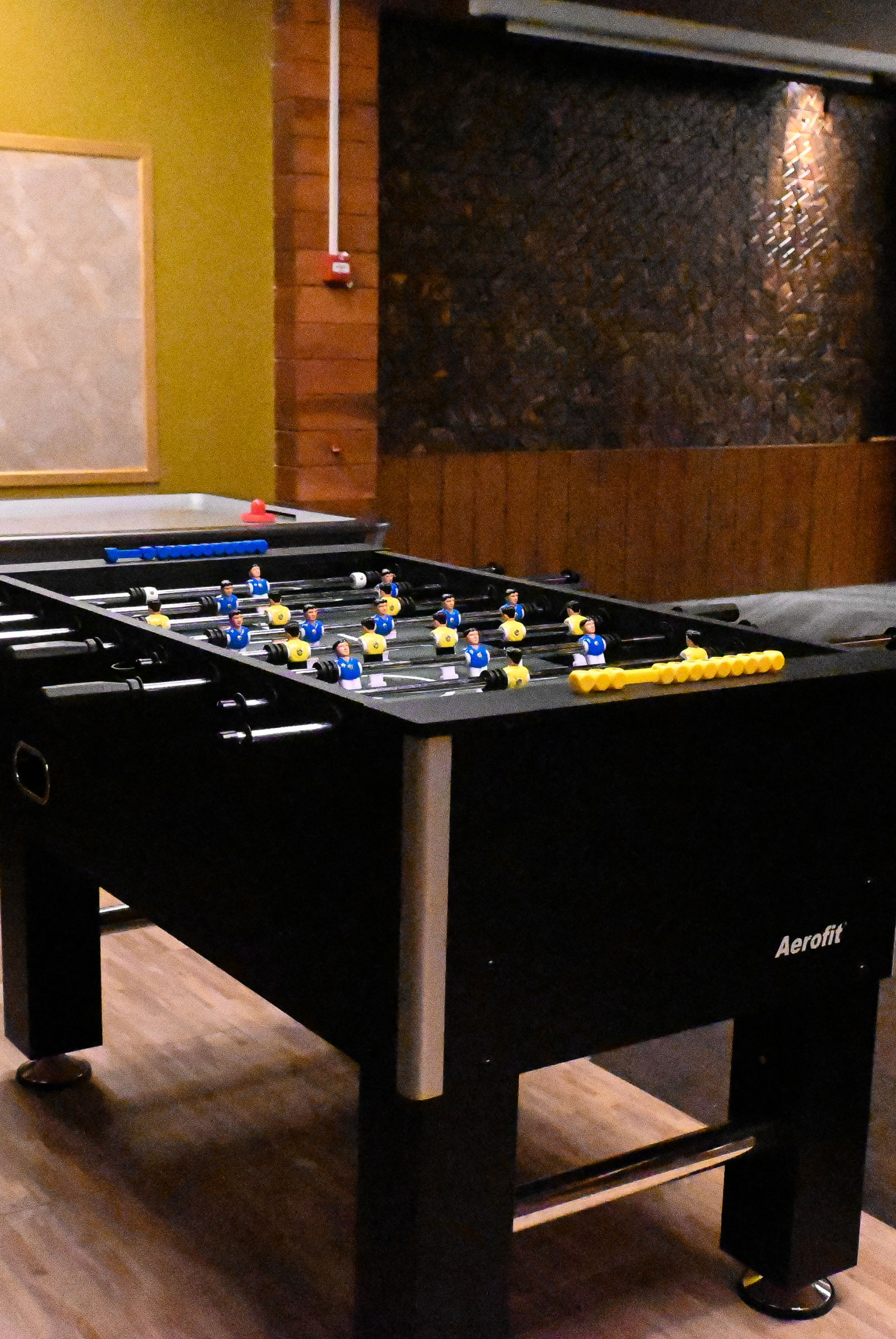 A game room with a Foosball table and an air hockey table in a warmly lit indoor setting - Coral Reef Resort & Spa, Havelock