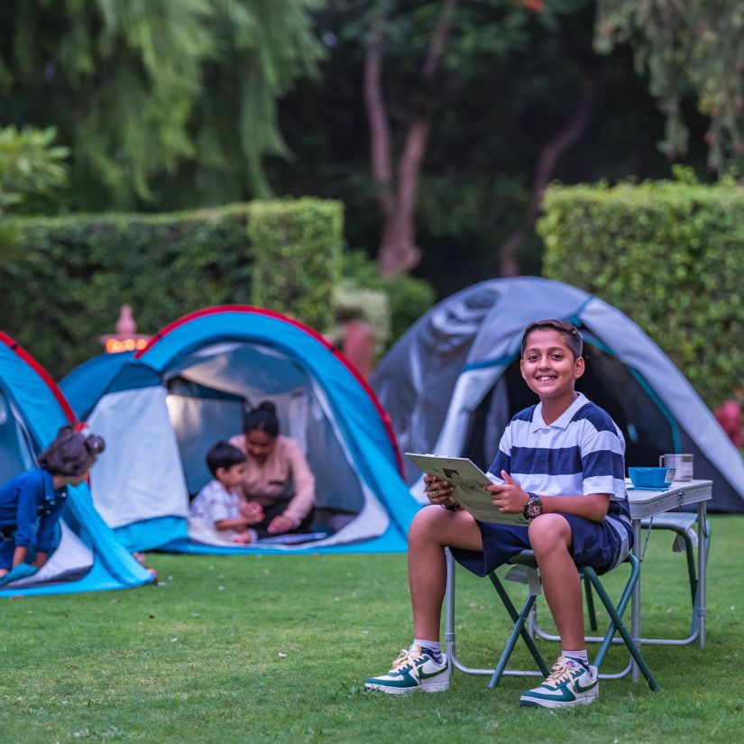 children playing in tents in the lush garden at Heritage Village Resort & Spa, Manesar