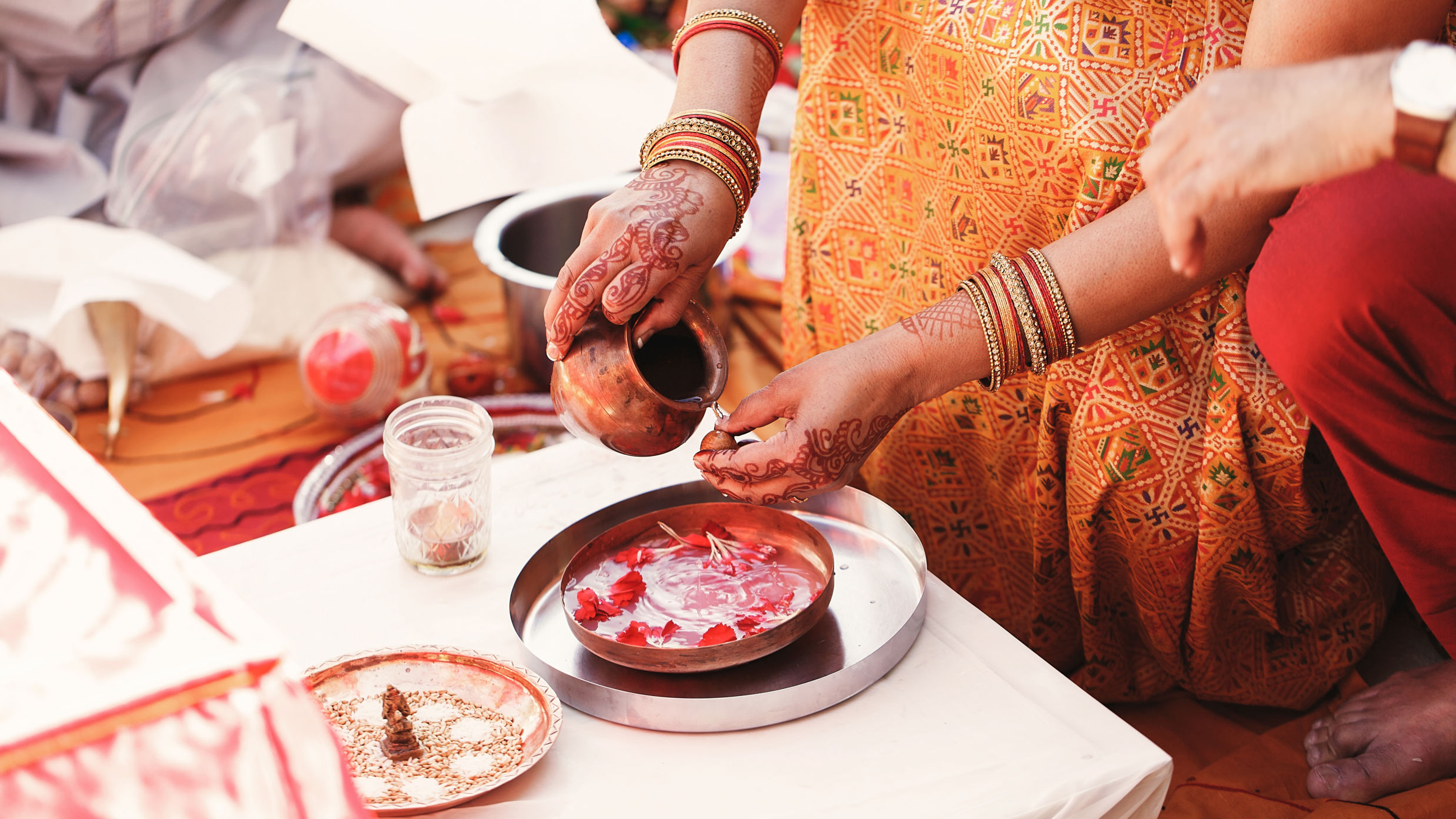 indian-bride-washes-nuts-plate-with-species-petals
