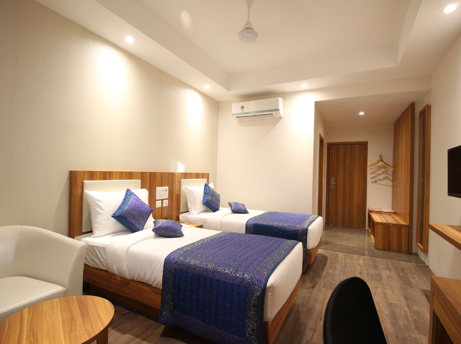 deluxe room with twin beds captured from different angles that showcase the in-room amenities and interior of the bedroom - le roi raipur hotel1