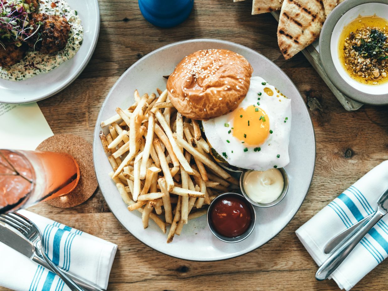 a plate served with bun, omelette and fries