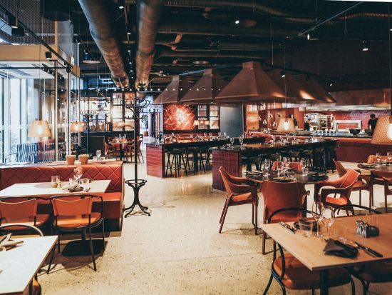 seating arrangements inside a restaurant with live counter on the side where chefs are preparing food