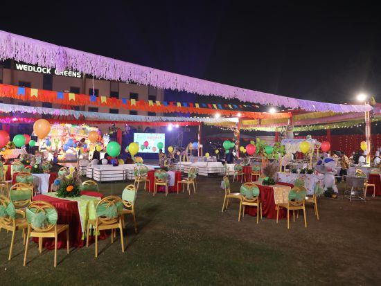 People gather in the outdoor venue, which is decorated for a celebration.