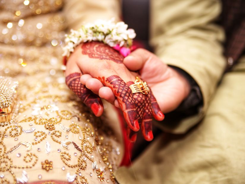 a couple holding hands during a wedding ritual