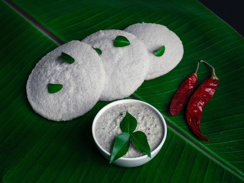 Idli and chutney served on a plantain leaf