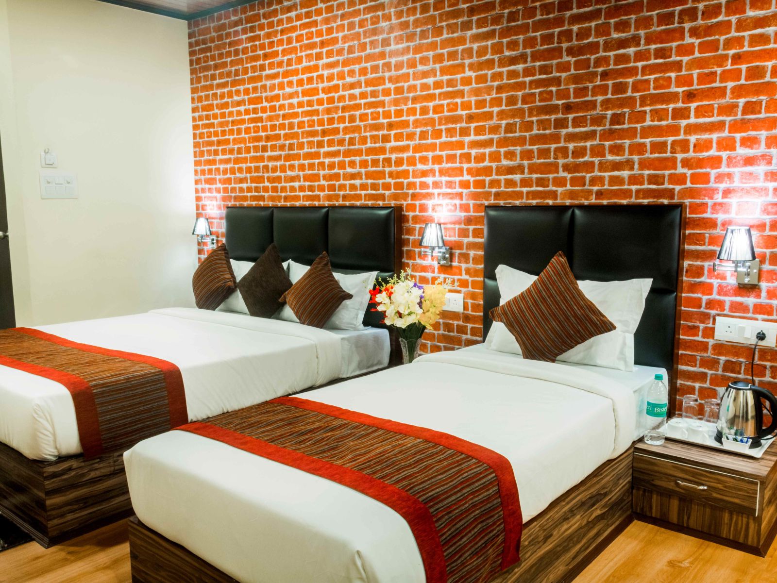 An image of the deluxe room with twin bed, bed side tables, and other modern amenities - Ecotel Tin Tin, Bijanbari