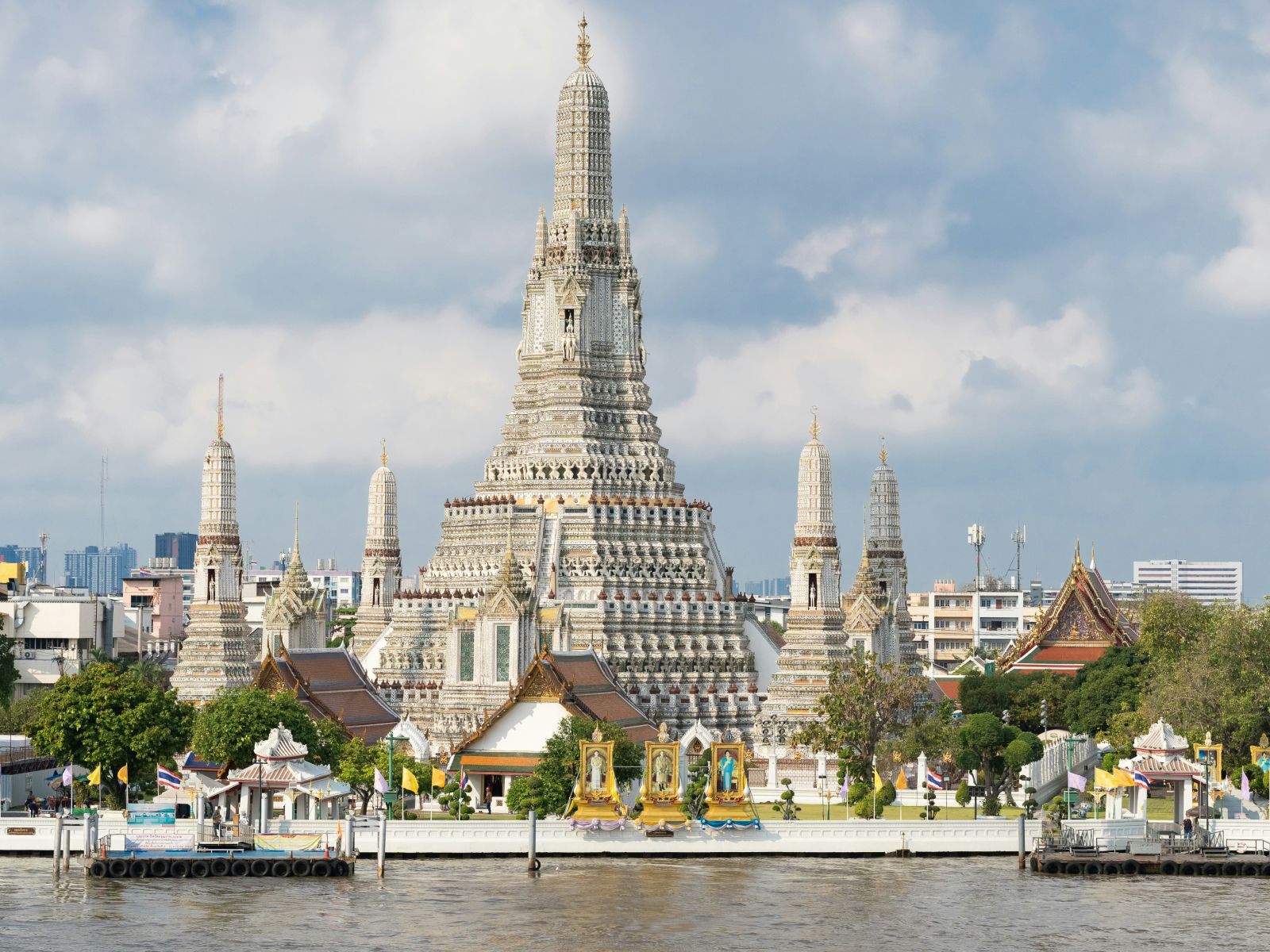 Facade image of Wat Arun with white clouds on blue sky in the background