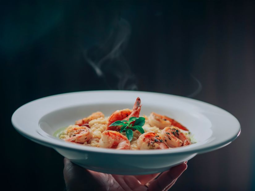 man holding the plate with delicious food elegently