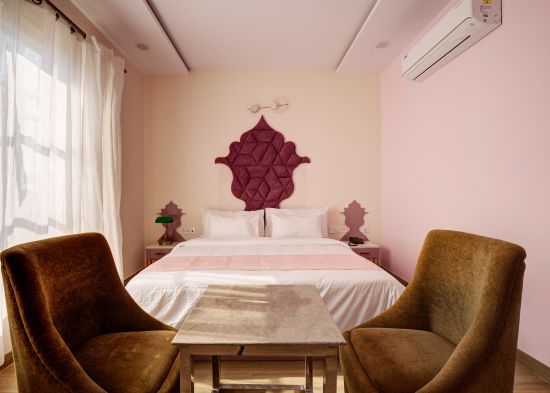 alt-text Pink themed Super Deluxe Room with chairs - The White Moon