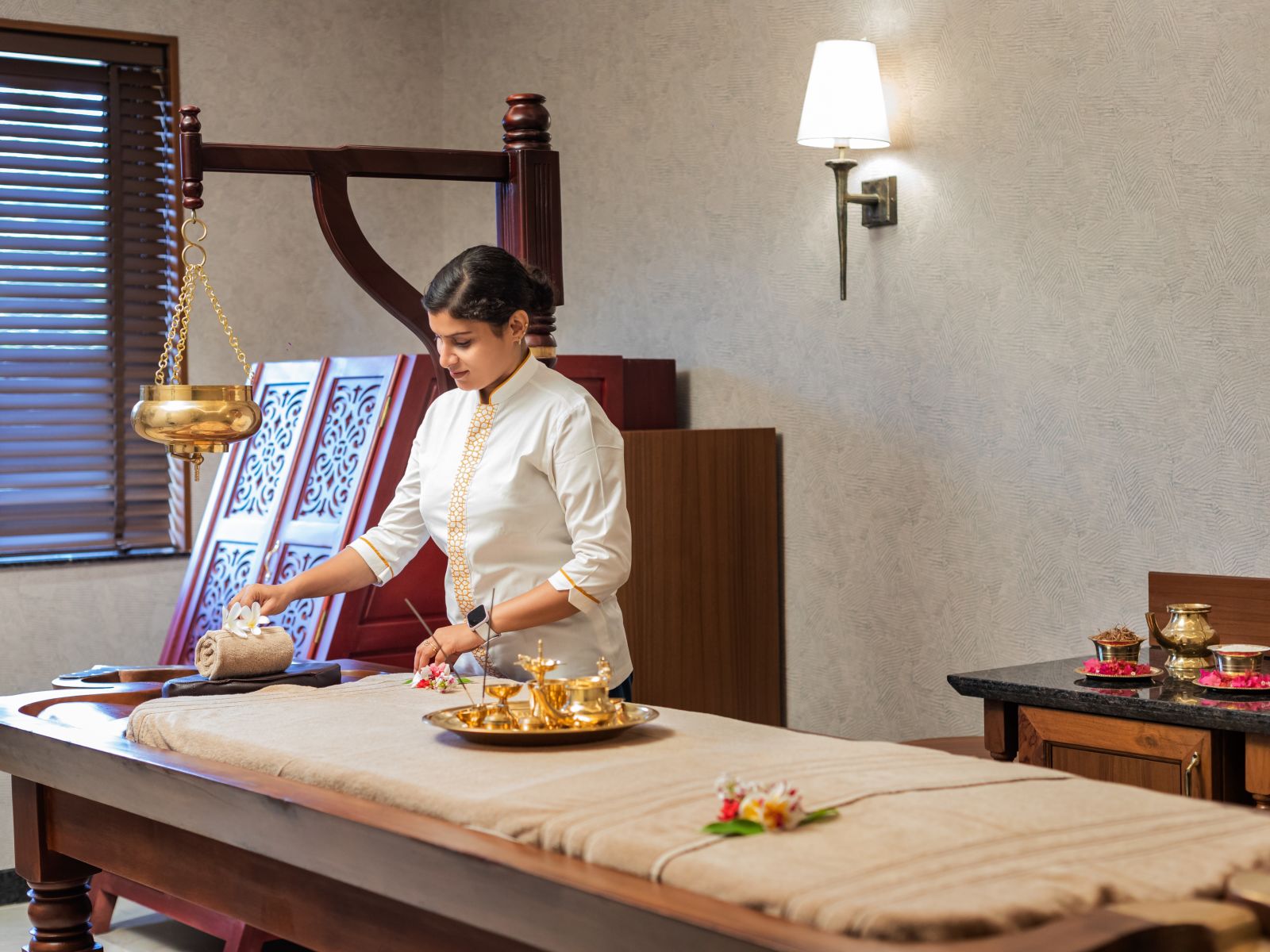 a massage therapist preparing a spa bed