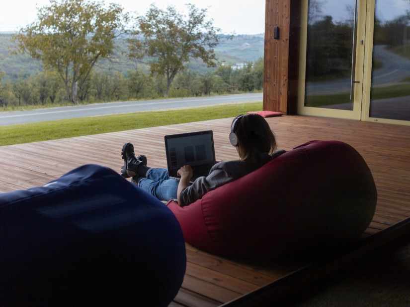 a person using a laptop on a beanbag