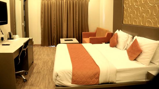 a warmly-lit classique room at Comfort Inn Silver Arch Mussoorie featuring comfortable bed and modern amenities