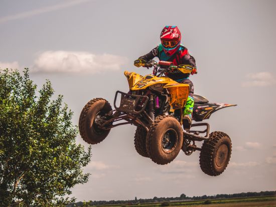 a person riding a black and yellow atv motorbike