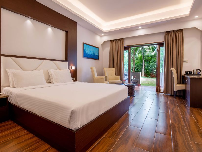 a double bed with side tables inside deluxe room at avana resort - Black Thunder, Coimbatore