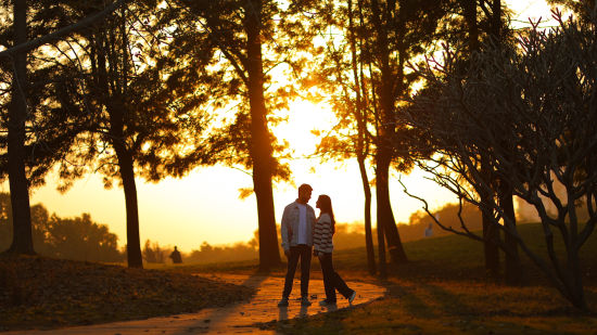 a couple standing on a gold course during sunset - Karma Lakelands