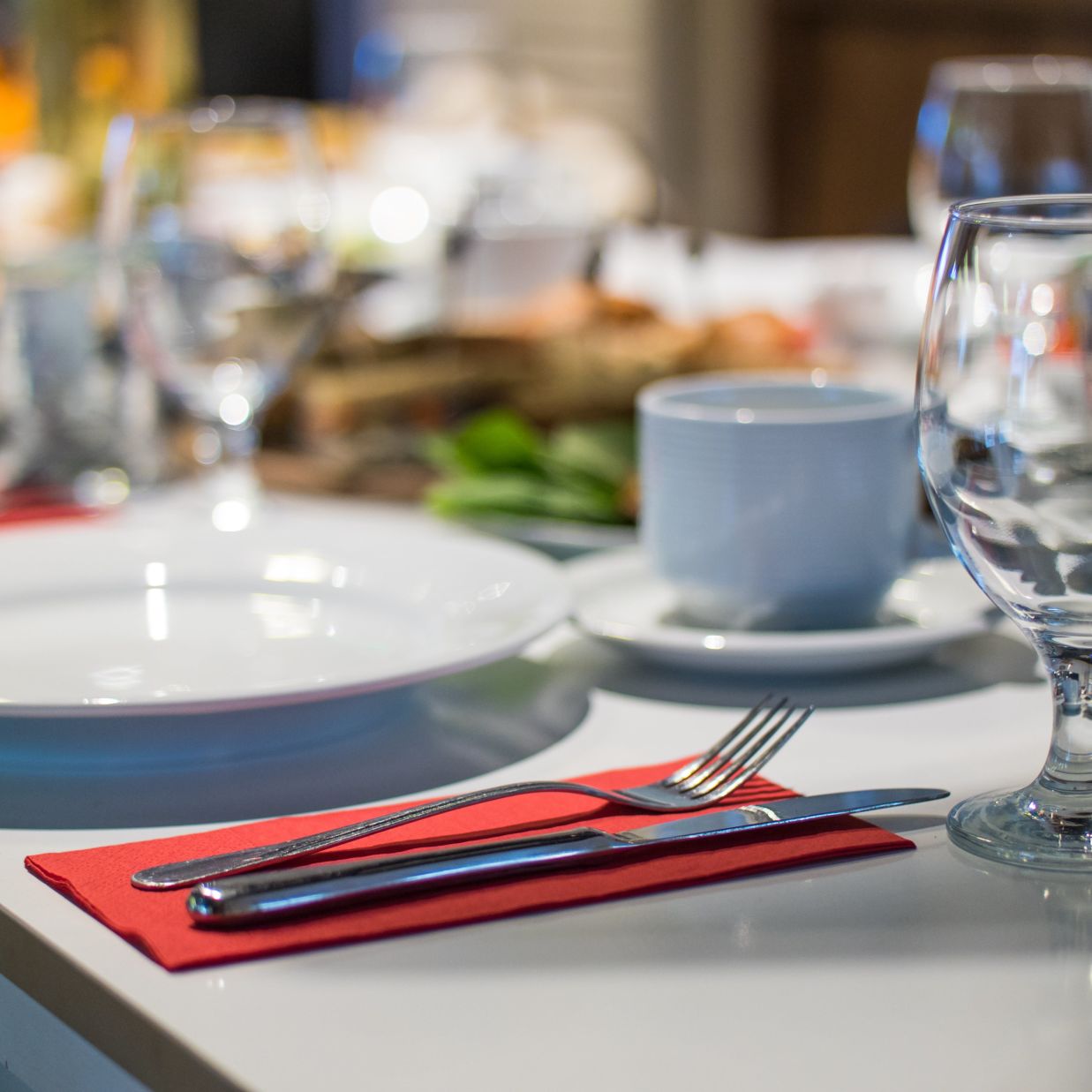 a restaurant table with plates, utensils and glasses